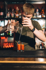 Vintage portrait of bartender creating cocktails at bar. Close up of alcoholic beverage preparation