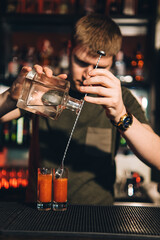 Vintage portrait of bartender creating cocktails at bar. Close up of alcoholic beverage preparation