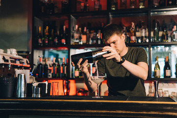 Vintage portrait of bartender creating cocktails at bar. Close up of alcoholic beverage preparation