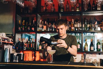 Vintage portrait of bartender creating cocktails at bar. Close up of alcoholic beverage preparation
