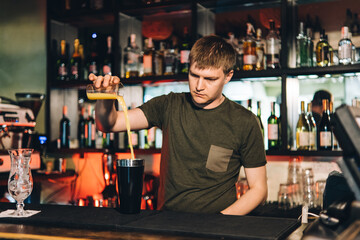 Vintage portrait of bartender creating cocktails at bar. Close up of alcoholic beverage preparation