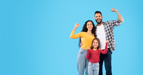 Happy Arabic Family Showing Biceps Standing Over Blue Studio Background