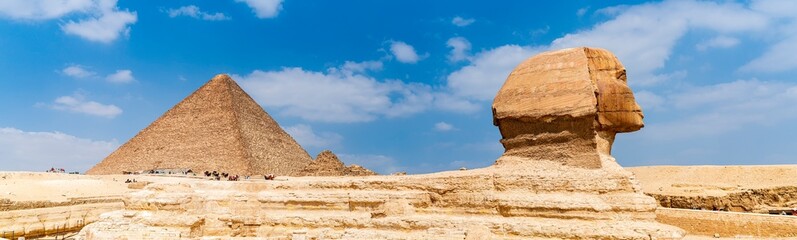 Panoramic photograph of the Sphinx of Giza whose back is dominated by one of the great pyramids....