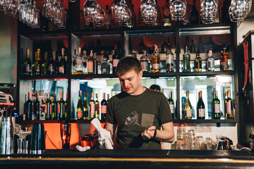 Vintage portrait of bartender creating cocktails at bar. Close up of alcoholic beverage preparation
