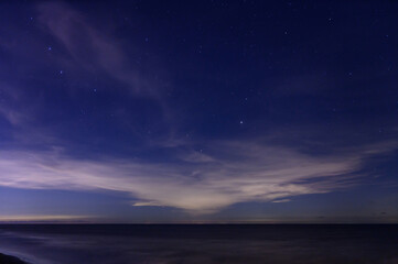 Fototapeta na wymiar Starry night sky over calm sea beach.