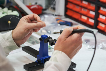 Close up of a technician tin soldering an electronic component.