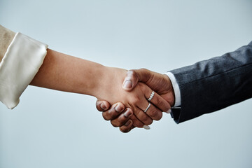 Minimal closeup of two business partners shaking hands in greeting against minimal white background, copy space
