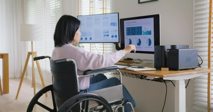 Asian disability woman with wheelchair busy work online multiple screen laptop computer or smart tablet at home in freelance sale data analytic, data science scientist engineer for business