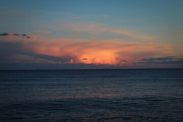 Fototapeta na wymiar Nube curiosa al atardecer sobre el mar