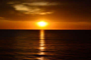 Sunset over the ocean. Blurry abstract art background in digital motion effect.