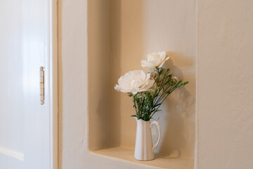 Wall inset with pitcher of flowers.