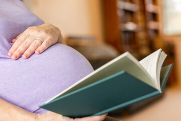 Pregnant woman reading a book on parenting and sleep