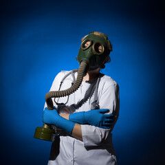 doctor woman in a gas mask and gloves hugged herself with her hands on a blue background
