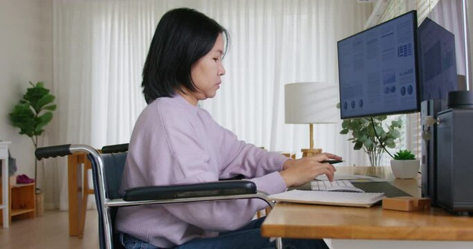 Asian disability woman with wheelchair busy work online multiple screen laptop computer or smart tablet at home in freelance sale data analytic, data science scientist engineer for business