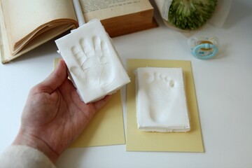 Baby handprint and footprint on womans hand with copy space. parents memories. New life concept