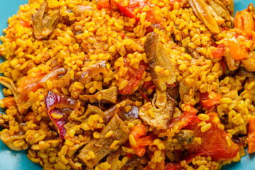 bulgur with vegetables and mushrooms in golden spices close-up.