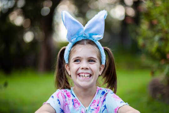 Grinning little girl with Easter bunny ears outside