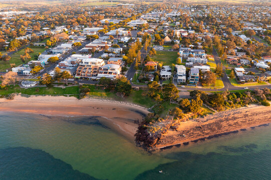 Aerial view of a coastal town behind a bluff and a foreshore reserve