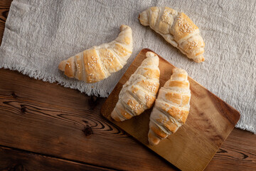 Freshly baked croissants on wooden background. Homemade croissants