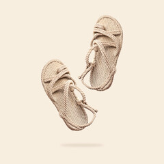 Summer female wicker sandals isolated on beige background. Fashionable trendy rope straw sandals. Jute slippers. Handmade Eco-friendly natural shoes. Cut out objects for design, Mock up - obrazy, fototapety, plakaty