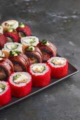 Sushi set. Roll Philadelphia, California Black, with fresh ingredients on stone background.