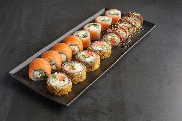 Sushi set. Roll Philadelphia, Tempura Salmon, with fresh ingredients on stone background.