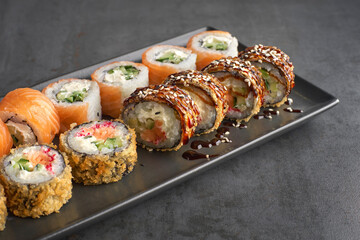 Sushi set. Roll Philadelphia, Tempura Salmon, with fresh ingredients on stone background.