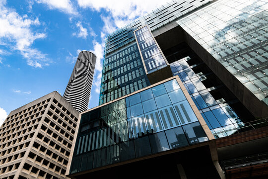 Looking up at skyscrapers with reflections, geometric patterns and converging lines to sky