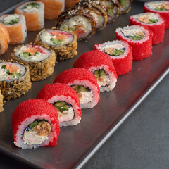 Sushi set. Roll Philadelphia, California Black, with fresh ingredients on stone background.