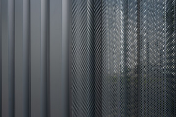 Texture of a perforated and corrugated sheet metal aluminum facade.