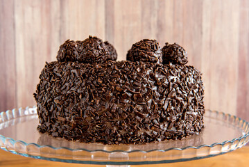 Chocolate cake with brigadeiro grains, delicious dessert on a wooden background.