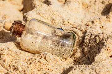 Strandgut am Meer, alte Flasche im Sand am Strand.