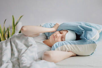 woman lies in bed and covers her head with pillows. the woman suffers from insomnia or sleep disorders. noise prevents you from sleeping at night. a tired woman can't sleep. depression and sleep - obrazy, fototapety, plakaty