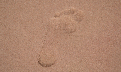 Fototapeta na wymiar Footprints in sand at beach, lonely trace on sandy surface on coast