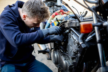 Fototapeta na wymiar a man repairs a motorcycle, motorcycle maintenance.