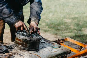 lubrication of bearings with lubrication by hands in the turbine fan of the car. Dirty hands in black grease.