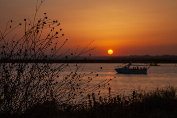 Long shot of a boat moored at sunset at the beach 