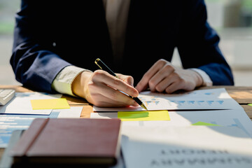 Business man checking financial documents, he owns a startup company, he sits checking the company's financial summary prepared by the finance department. Management concept of startup company.