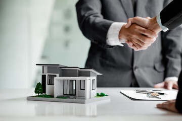 The salesperson of the housing estate in the project and the customer shake hands after...