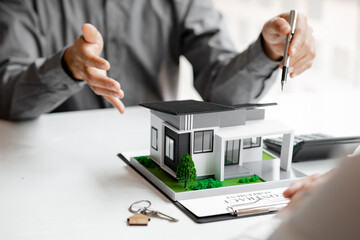 Real estate agents explain models of housing estates in projects to elaborate to clients,...
