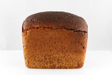Loaf of black bread on white. Close-up.