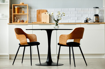 Minimal background image of black kitchen table set with two wooden chairs, copy space