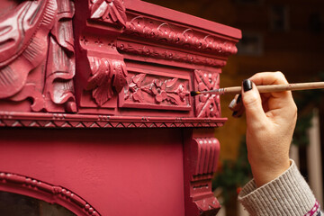Scrupulous process of patinating furniture. Woman hand with brush aging wooden cupboard with...