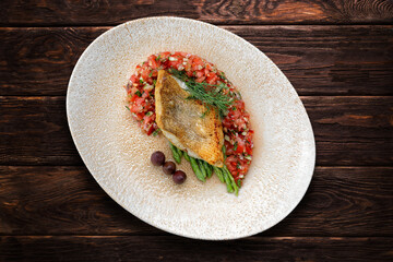 A piece of fried fish pike perch with vegetables