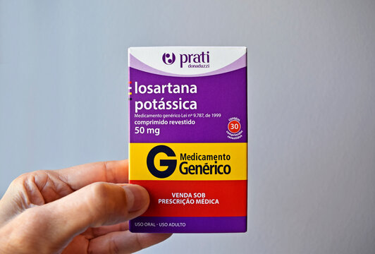 RIO DE JANEIRO, BRAZIL - APRIL 21, 2022: Hand holding a box of (generic) losartan potassium, medication to control hypertension 