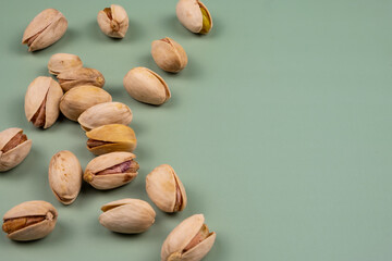 Close-up of organic pistachios on a green table. Health concept with copy space. 