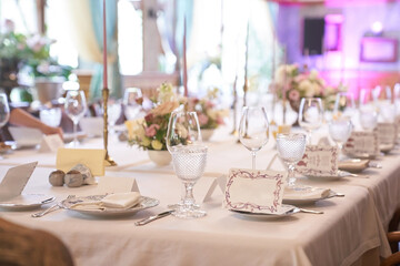 Luxurious table setting for a holiday in pastel colors close-up.Empty wine glasses placed in the restaurant. Part of the interior. High quality photo