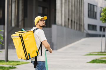 Delivery man of takeaway on scooter with isothermal food case box. Express food delivery service...