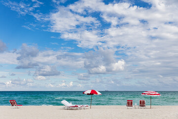 Red and white striped beach chairs and umbrellas on Miami Beach 