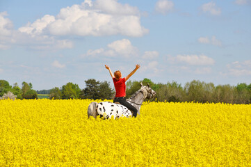 Woman and horse in rape field